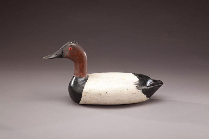 Canvasback Drake: Canvasback Drake Jack Eppel (b. 1899) Peoria, IL, c. 1940 A high-head hollow decoy displaying glass eyes, a shelf tail, and an incised "A" rig mark on the underside. Old paint with a light wash of wor