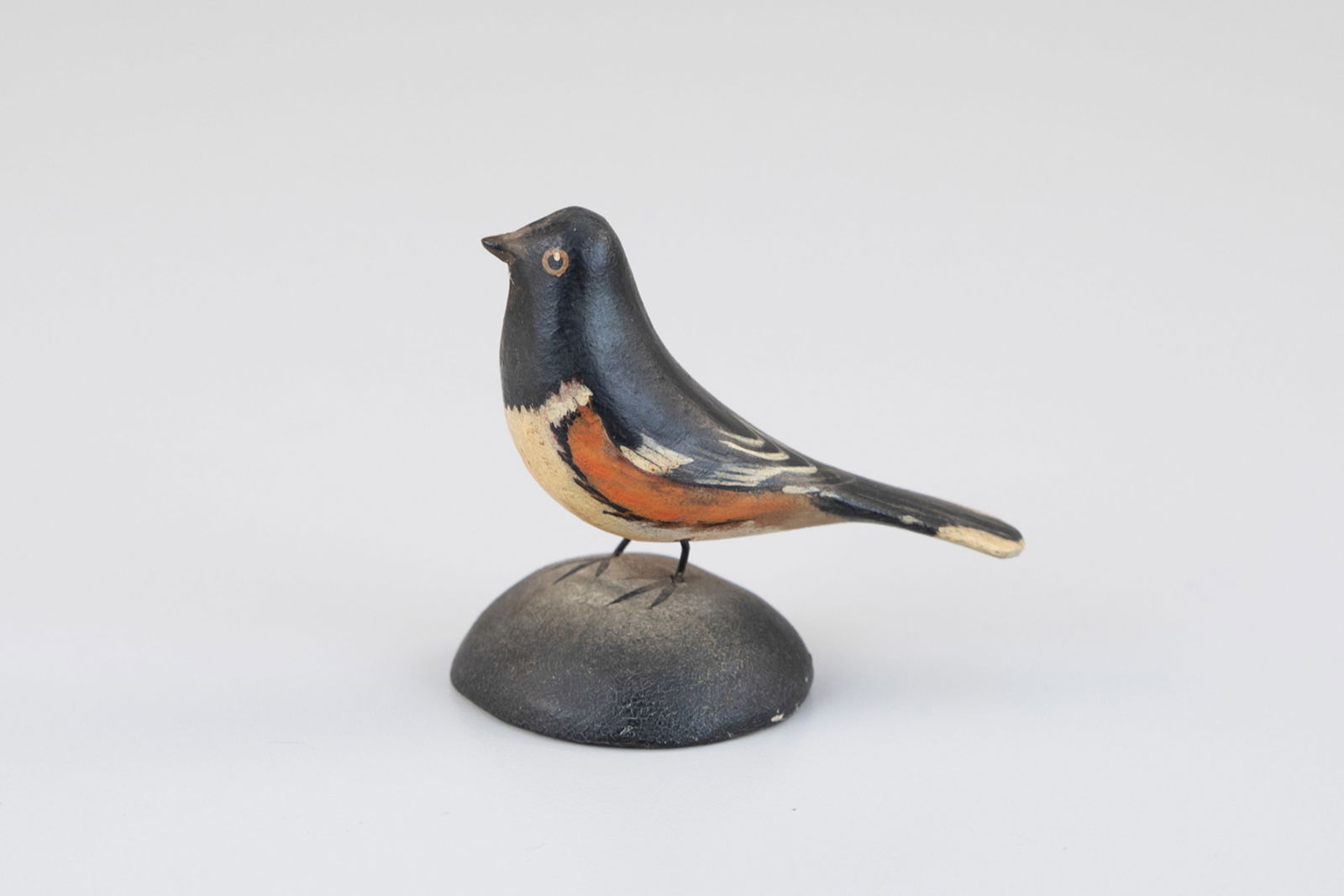 Miniature Towhee by A. Elmer Crowell (1862-1952): Miniature Towhee A. Elmer Crowell (1862-1952) East Harwich, MA, c. 1920 2 1/2 in. tall This carving is Inscribed "Chewink or Tohee [sic]" and bears Crowell's circular "Maker" ink stamp on the undersid