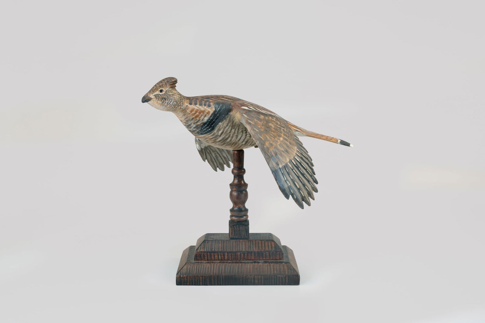 Flying Ruffed Grouse Carving by Mike Borrett (b. 1960): Flying Ruffed Grouse Carving Mike Borrett (b. 1960) Madison, WI, 2001 16 in. tall on base Signed and dated on the left wing and mounted on a decorative base. Original paint with minimal wear and