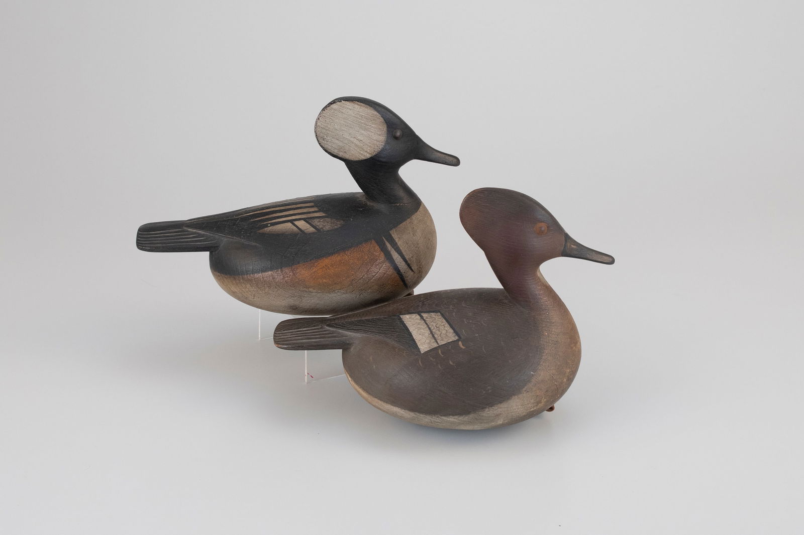 Hooded Merganser Pair by Mark McNair (b. 1950): Hooded Merganser Pair Mark McNair (b. 1950) Craddockville, VA, c. 1985 11 in. long Each has raised wing tips, incised tail feathers, and the undersides bear the incised "McNair" signature. Original pa