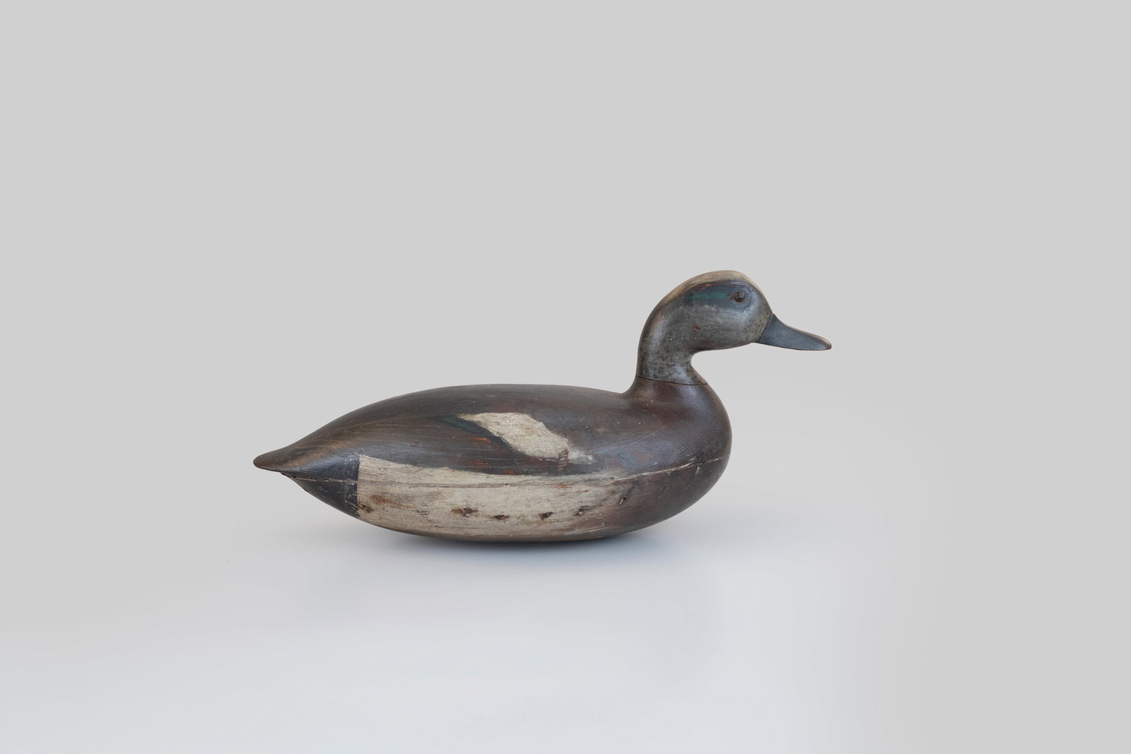 Swimming Wigeon Drake by John Blair Sr. (1843-1929): Swimming Wigeon Drake John Blair Sr. (1843-1929) Philadelphia, PA, c. 1870 14 1/2 in. long An exceptionally hollow, round-bottomed Delaware River decoy with a thin neck and grand form. This early deco