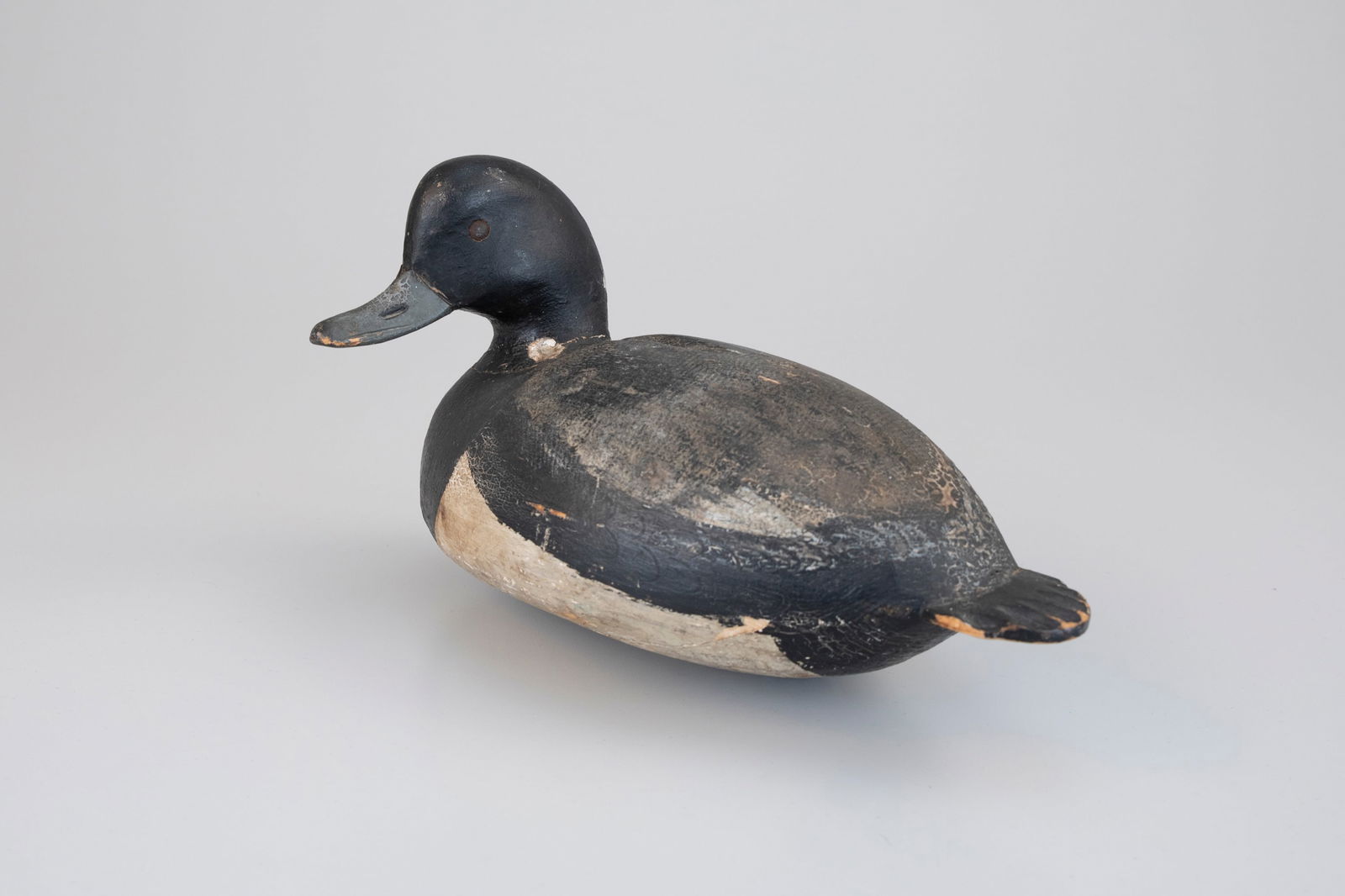 Turned-Head Bluebill by Ira D. Hudson (1873-1949): Turned-Head Bluebill Ira D. Hudson (1873-1949) Chincoteague, VA, c. 1920 11 1/2 in. long This full-bodied decoy exhibits one of Virginia's most dramatically turned heads, cranked ninety degrees to