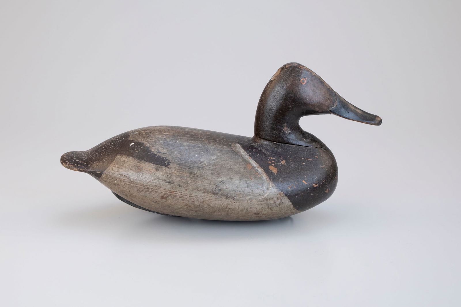 Pennock Rig Canvasback Hen by William Heverin (1860-1951): Pennock Rig Canvasback Hen William Heverin (1860-1951) Charlestown, MD 15 in. long Original paint on the back with old working paint to the brown with gunning wear.