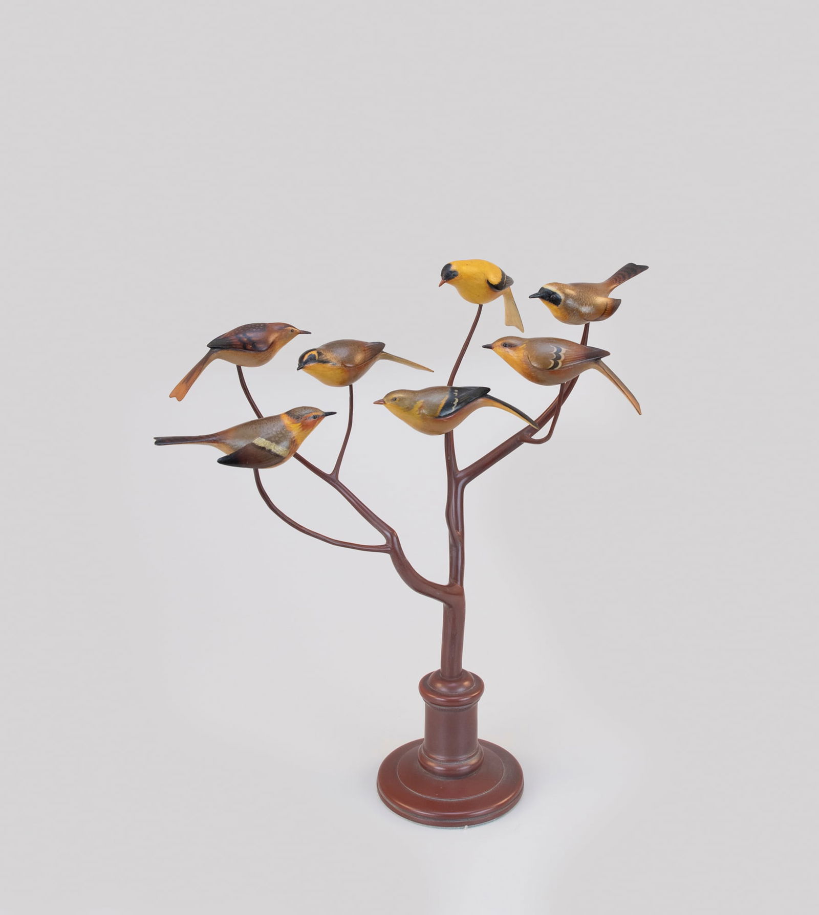 Bird Tree with Seven Songbirds by Lloyd Cargile (b. 1938): Bird Tree with Seven Songbirds Lloyd Cargile (b. 1938) Baltimore, MD 19 in. tall. A turned base with a finished branch hosting seven animated life-size songbirds, including a goldfinch, wren, and yell