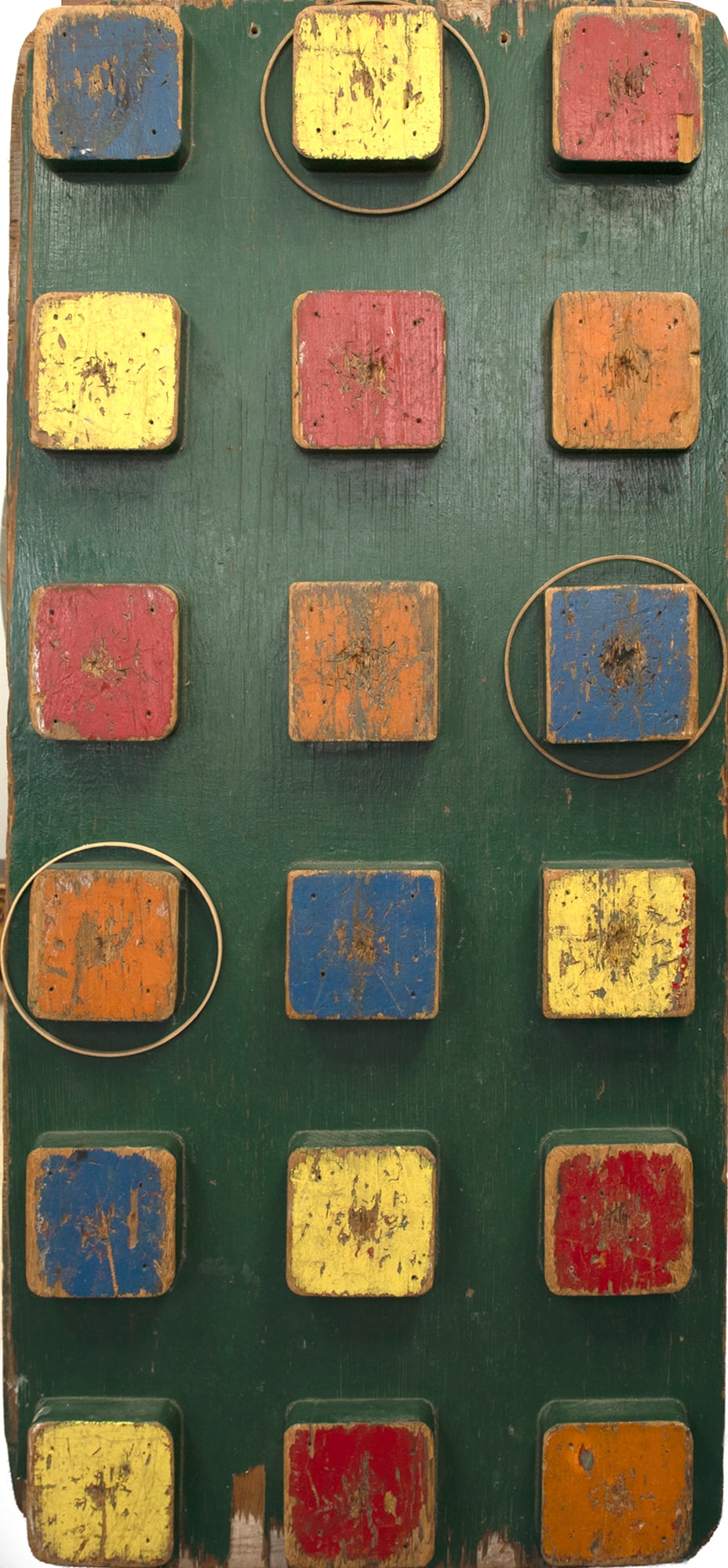 Carnival Game Board: Carnival Game Board 53 1/4 by 24 by 2 1/2 in. A grid of eighteen painted squares in red, yellow, blue, and ochre against a deep green background. Used as a target board, each square appears to have