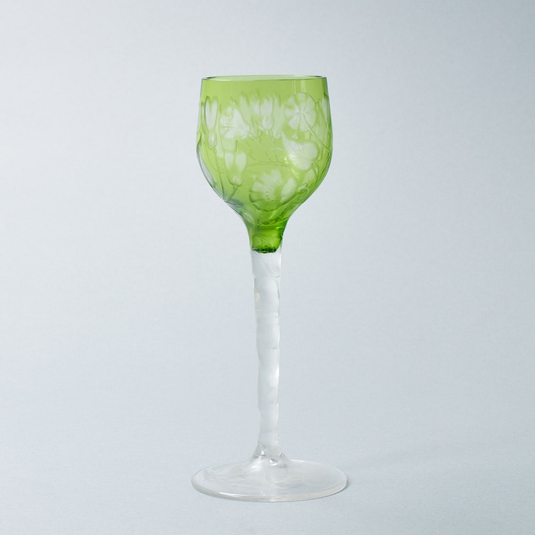 Weinglas mit unterschiedlichen Blumen. Ludwig Moser & Söhne, Karlsbad um 1902.: Weinglas mit unterschiedlichen BlumenLudwig Moser & Söhne, Karlsbad um 1902. Farbloses Glas. Kuppa mit grünem Überfang. Auf Fuß, Schaft und Kuppa gravierte unterschiedliche Blumenm