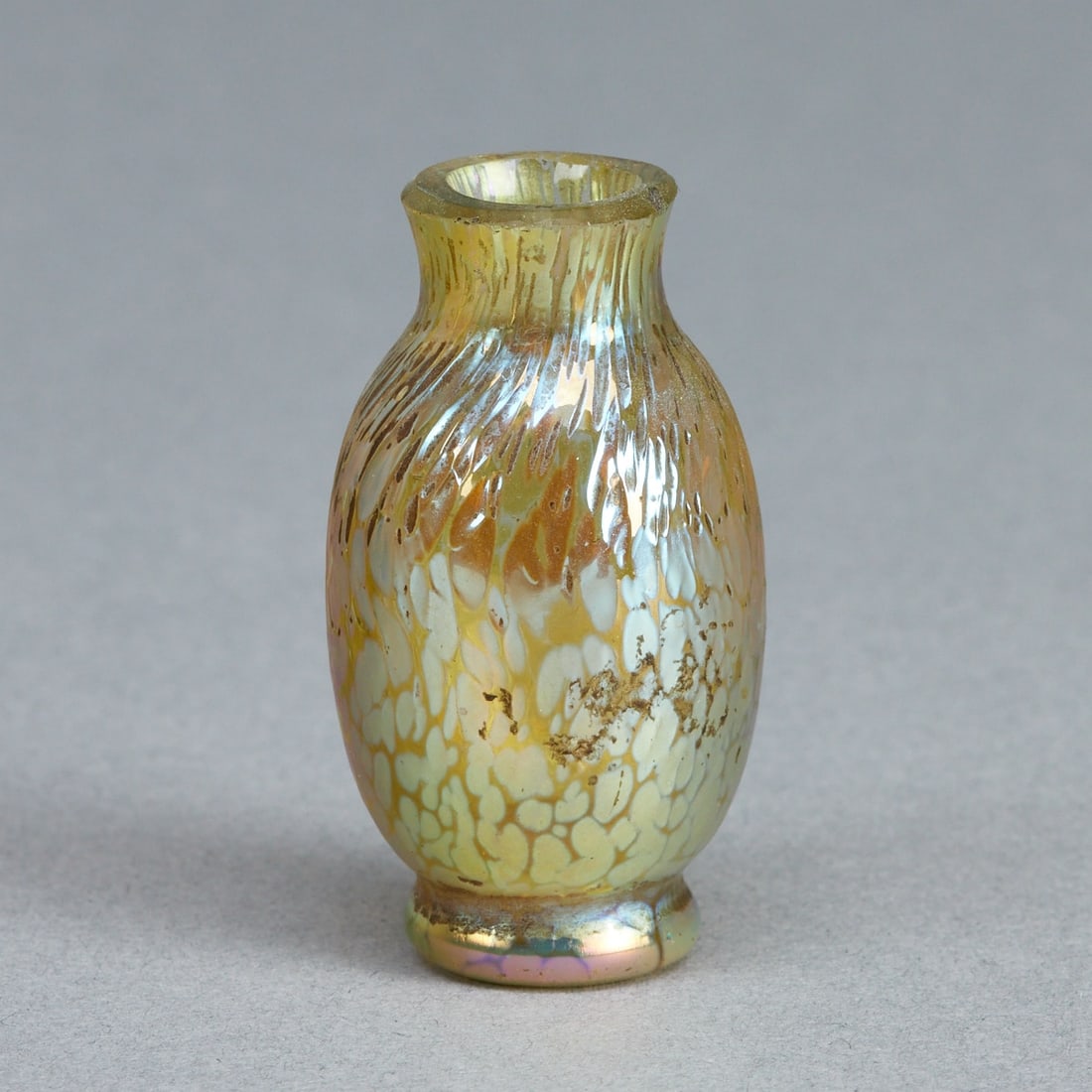 Miniaturvase - Papillon. Johann Loetz Wwe., Klostermühle um 1900.: Miniaturvase - PapillonJohann Loetz Wwe., Klostermühle um 1900. Farbloses Glas, mit gelb-blau-silbrigen Aufschmelzungen. Irisierende Oberfläche. Ausgeschliffener Abriß. Unbezeichnet. H.