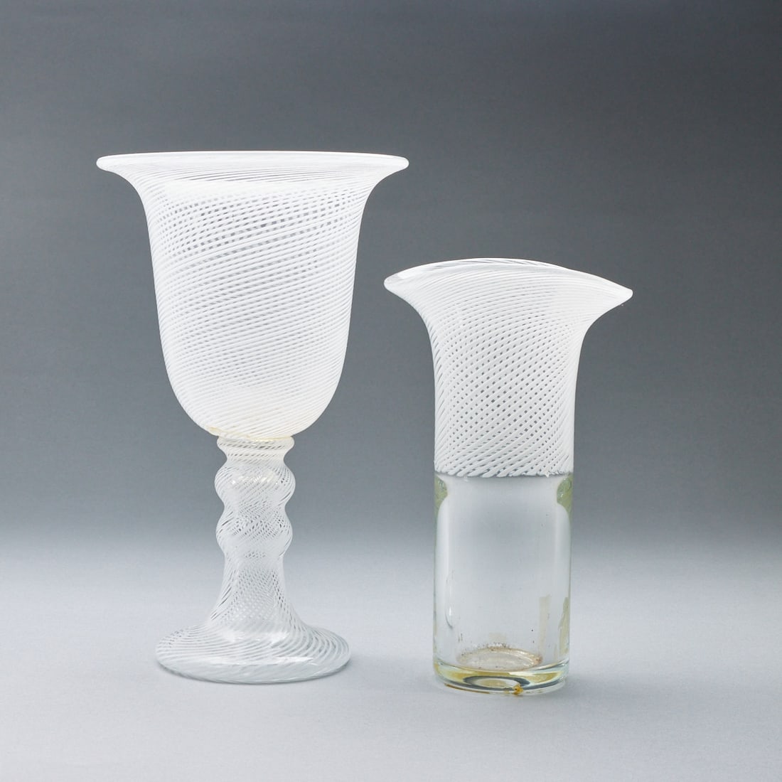 Pokal und Vase: Nuutajärvi.: Pokal und Vase1 Pokal - Nuutajärvi: Farbloses Glas mit eingeschmolzenen opakweißen, gedrehten Linien. Aufkleber: NUUTAJÄRVI 1793 WARTSH A FINLAND. H. 28 cm. -- 1 Vase - Heikki Orvola f&