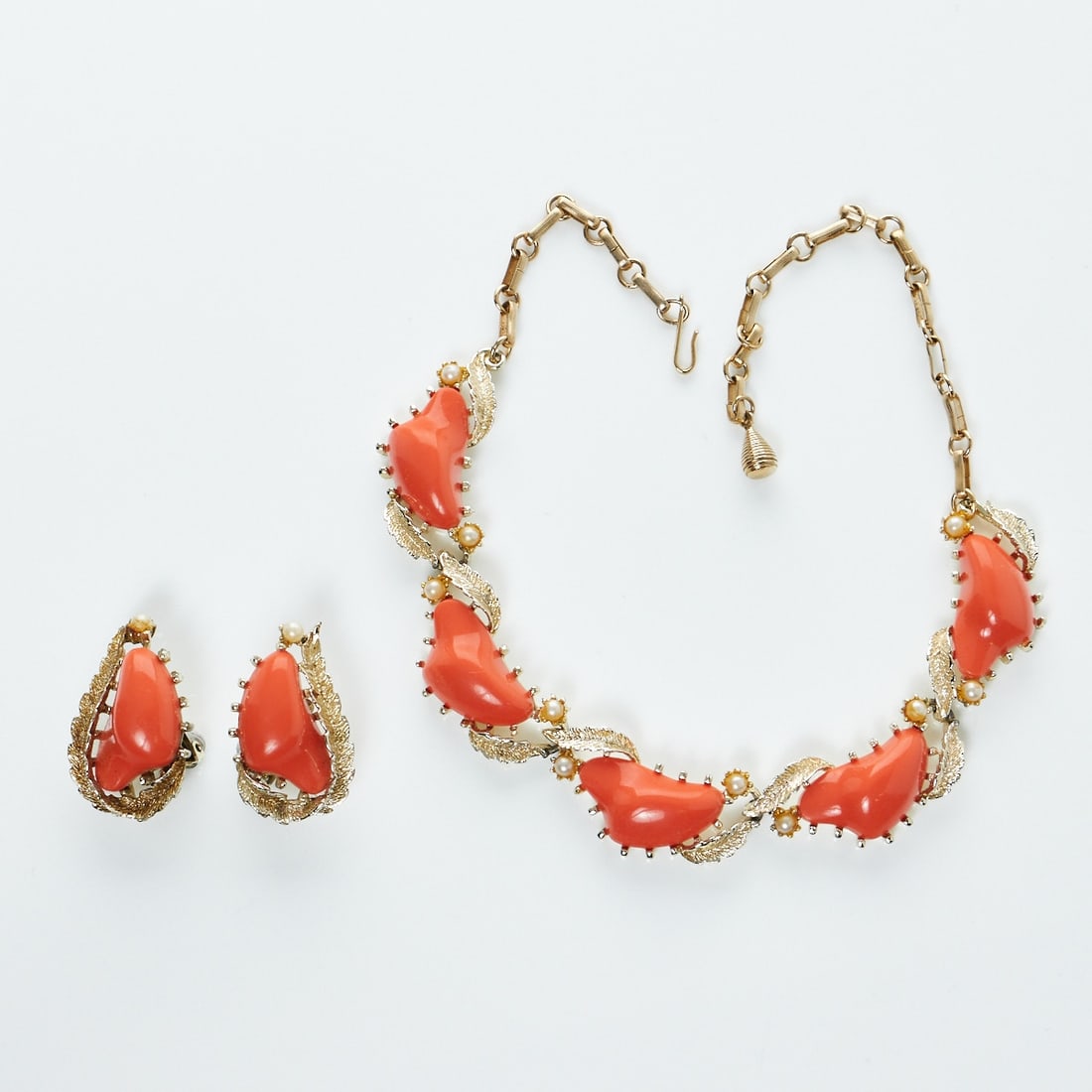 CORO - Vintage Collier mit Ohrclips in Koralle (2 Stück): CORO - Vintage Collier mit Ohrclips in Koralle (2 Stück)Coro Jewelry, Cohn & Rosenberger, Inc., New York, USA. 1970er - 1980er Jahre. Metall, Goldfarben. Kunststeine. Collier: 42 cm. B. 2,2 cm. O