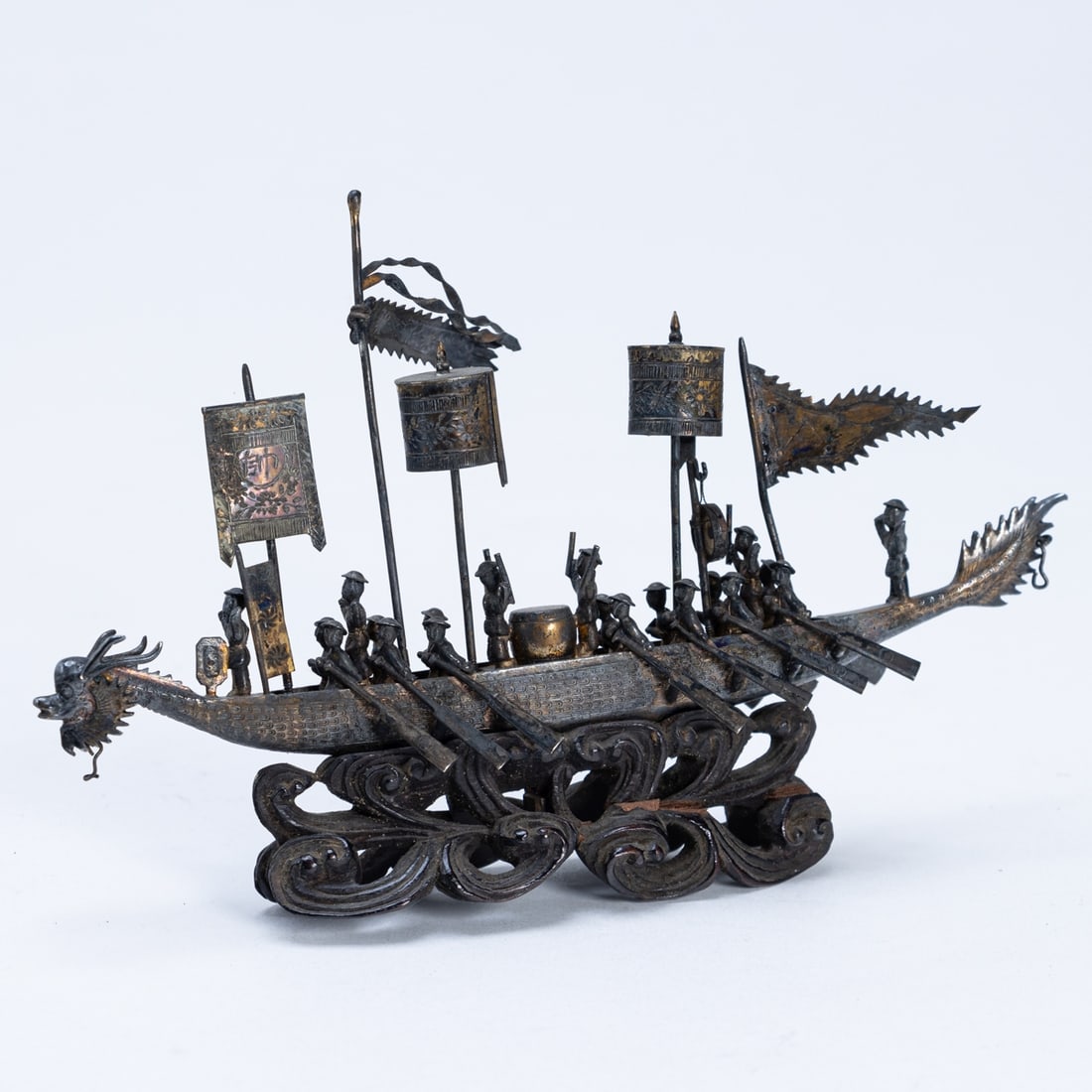 Chinesische Silberminiatur koenigliches Drachenboot: Chinesische Silberminiatur koenigliches DrachenbootChina, 20. Jahrhundert. Silber, m. wasserformigem Holzsockel. L. 15 cm. H. 9,5 cm. Alters- u. Gebrauchsspuren, Sockel wackelig. Drachenboot mit Schla