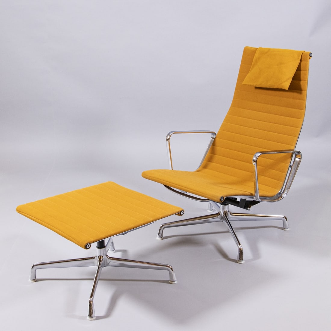 Lounge Chair EA 124 mit Ottoman: Lounge Chair EA 124 mit OttomanRing/Norwegen fuer Hermann Miller Entwurf: Charles & Ray Eames, um 1958. Aluminium. Hopsack. Herst.-Marken. Sessel 35/97 x 65 x 66 cm. Hocker 37 x 54 x 54 cm. Best.