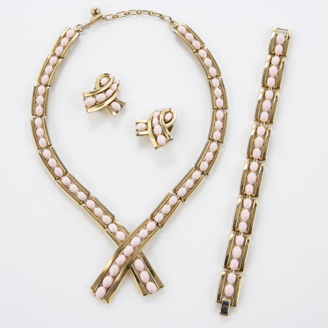 TRIFARI Alfred Philippe - Vintage rosa Glasperlen Schmuckset (3 Teile): TRIFARI Alfred Philippe - Vintage rosa Glasperlen Schmuckset (3 Teile)New York, um 1960-1970. Collier, Armband und Paar Ohrclips. Metall, goldfarben mit rosa Glasperlen. Collier-D. ca. 13 cm. B. ca. 4