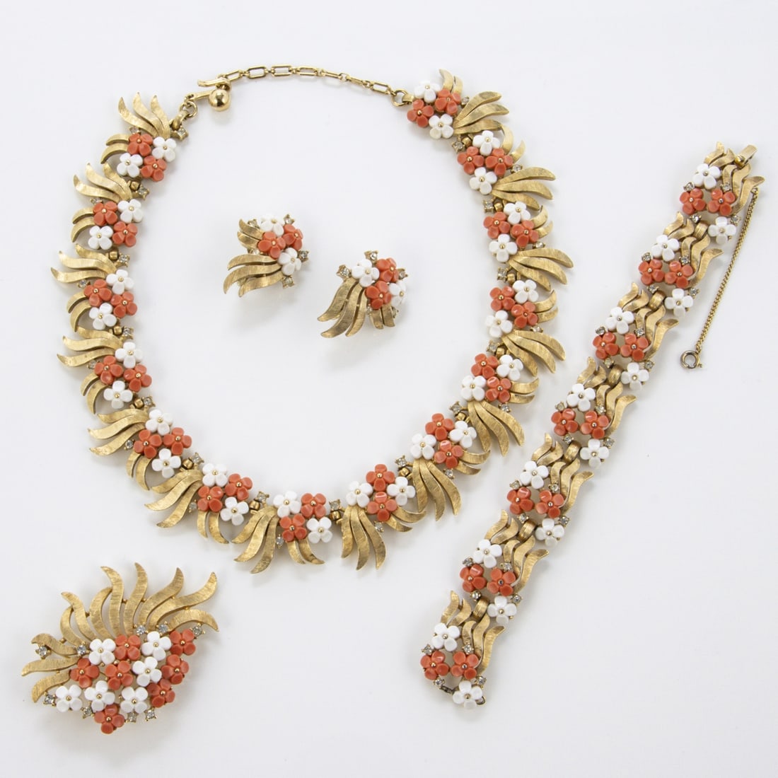 TRIFARI Alfred Philippe - Vintage-Schmuckset mit mit orangefarbenen und weissen Bluemchen (4 Teile): TRIFARI Alfred Philippe - Vintage-Schmuckset mit orangefarbenen und weissen Bluemchen (4Teile) New York, um 1940 - 1950. Collier, Armband, Brosche und Paar Ohrclips. Metall, goldfarben mit Strass und