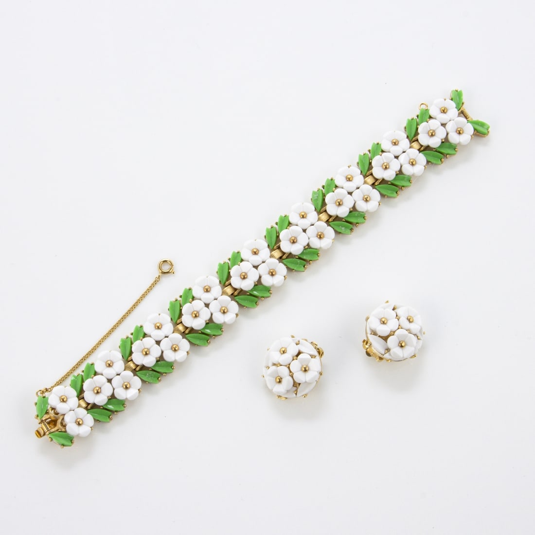 TRIFARI Alfred Philippe - Vintage-Schmuckset mit weissen Bluemchen (2 Teile): TRIFARI Krussman & Fishel Inc. - Vintage-Schmuckset mit weissen Bluemchen (2 Teile)New York, um 1940 - 1950. Armband und Paar Ohrclips. Metall, goldfarben mit Lucite. Armband-L.: 19 cm. B. 2,3 cm., mi