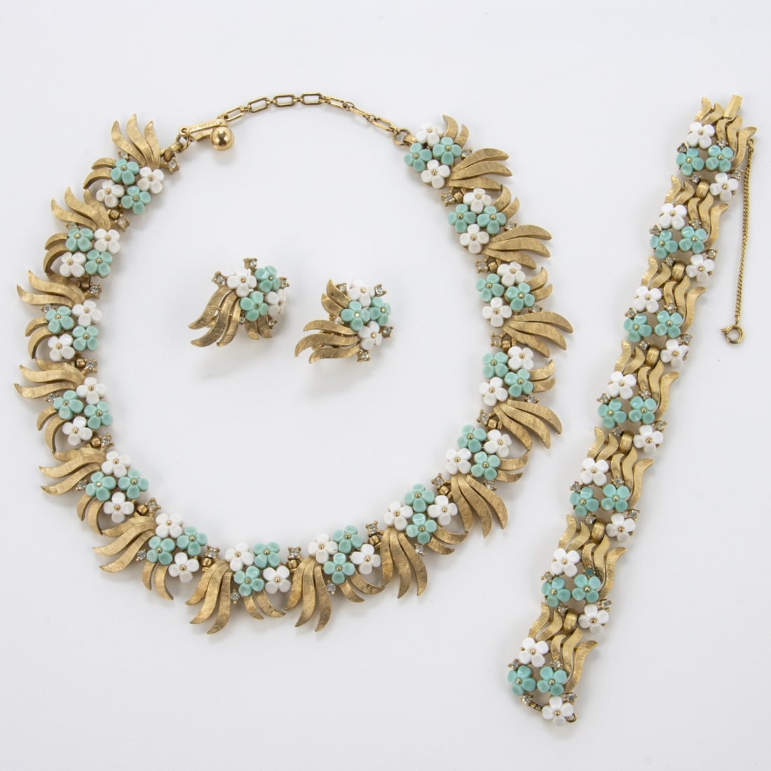 TRIFARI Alfred Philippe - Vintage-Set mit gruenfarbenen und weissen Bluemchen (4 Teile): TRIFARI Alfred Philippe - Vintage-Set mit blaufarbenen und weissen Bluemchen ''Forget MeNot' '(3 Teile) New York, um 1940 - 1950. Collier, Armband und Paar Ohrclips. Metall, goldfarben mit Strass, bla
