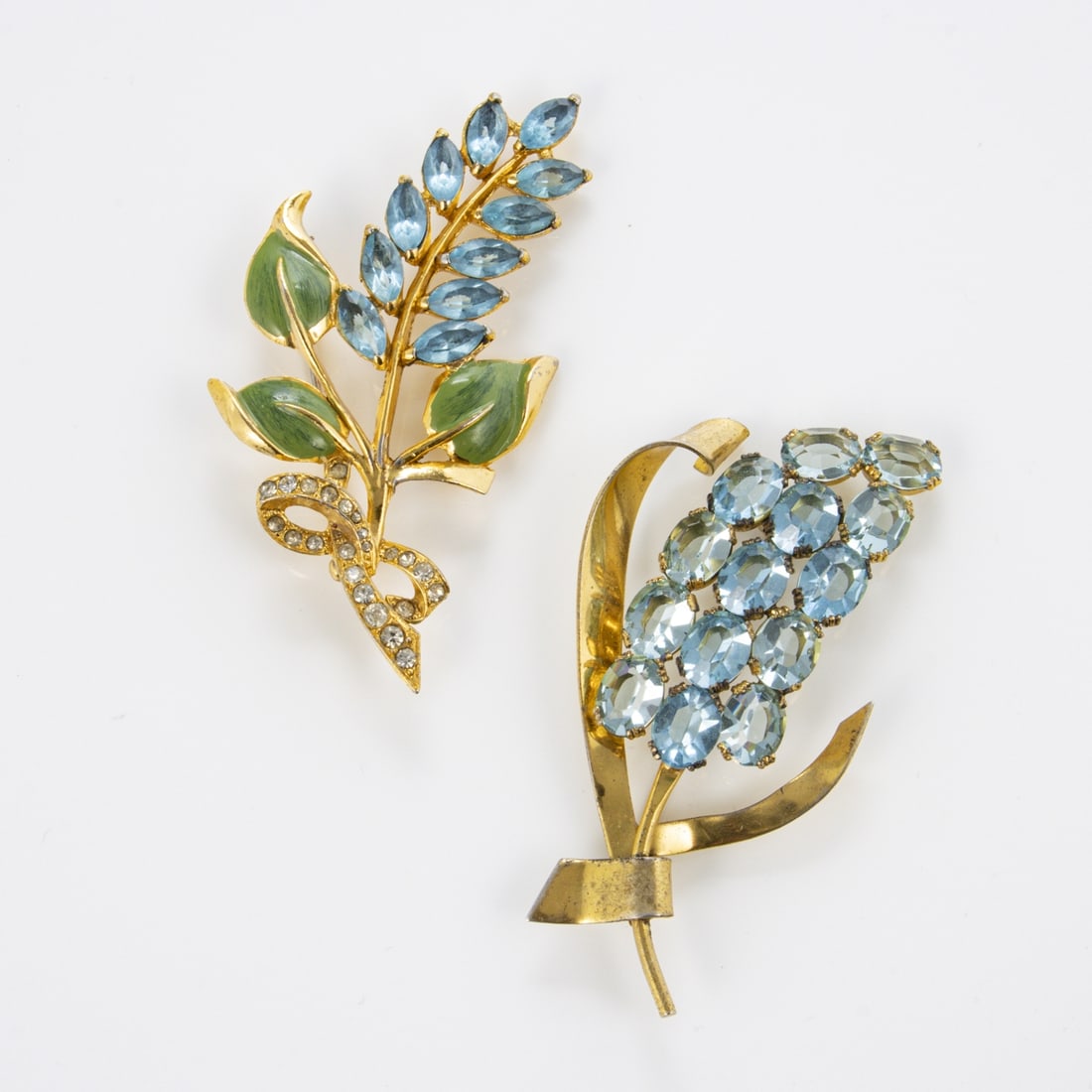 CORO - Zwei Vintage-Broschen mit blauen floralen Motiven: CORO - Zwei Vintage Broschen mit blauen floralen MotivenCoro Jewelry, Cohn & Rosenberger, Inc., New York, USA. ca. 1940 - 1960. Metall, Gold-platiniert (eine ist Sterling). Hellblaue aquamarinfarbene