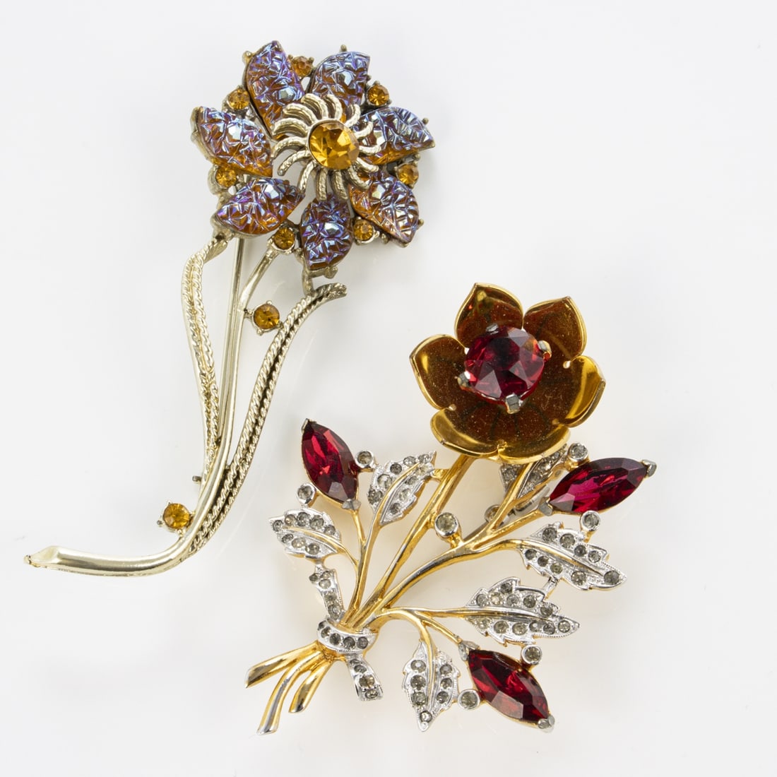 CORO - 2 Vintage Blueten-Broschen: CORO - 2 Vintage Blueten-BroschenCoro Jewelry, Cohn & Rosenberger, Inc., New York, USA. ca. 1940s - 1960s. Metall, Silber / Gold-platiniert. Polarlichter-Strasssteine, klare Strasssteine. Faux-Rubingl