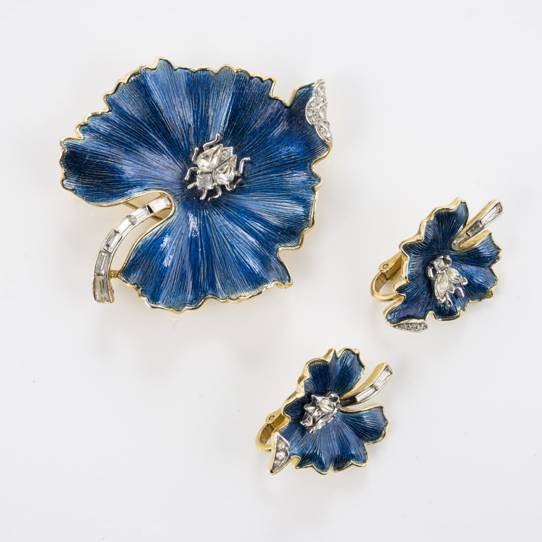 TRIFARI Alfred Philippe - Vintage Blaue Seerosen-Blaetter Brosche und Paar Ohrclips: TRIFARI Alfred Philippe - Vintage Blaue Seerosen-Blaetter Brosche und Paar OhrclipsNew York, um 1950. Brosche und Paar Ohrclips. Metall, goldfarben mit Strass, Emaille Blaue Seerosen-Blaetter mit Stra