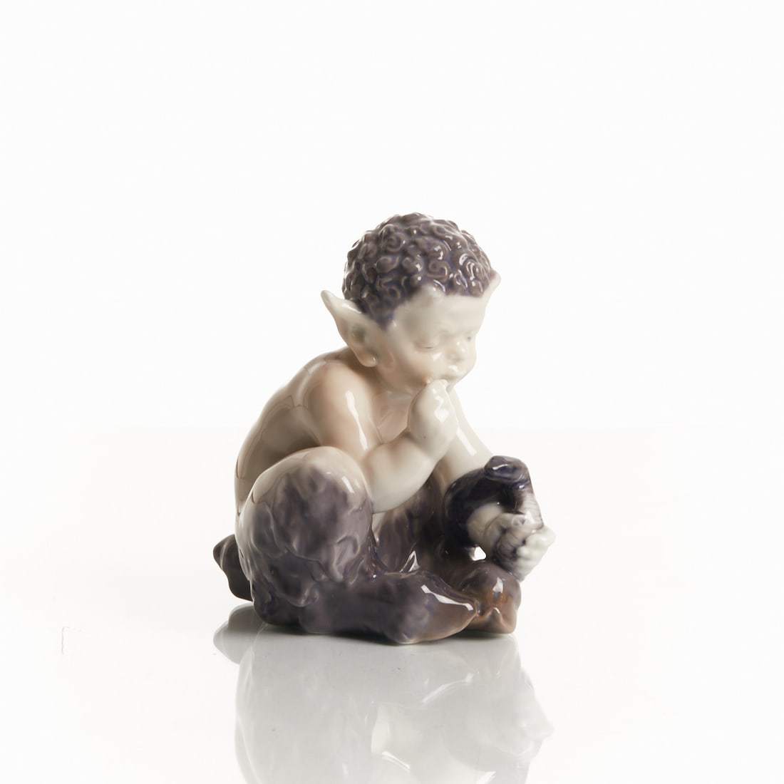 Faun with Snake - Christian Ludvig Thomsen, Royal Copenhagen 1923: Faun with Snake - Christian Ludvig Thomsen. Royal Porcelain Manufactory, Copenhagen 1923. White, glazed porcelain. Polychrome pastel painted underglaze. Green mark and three blue wavy lines underglaze