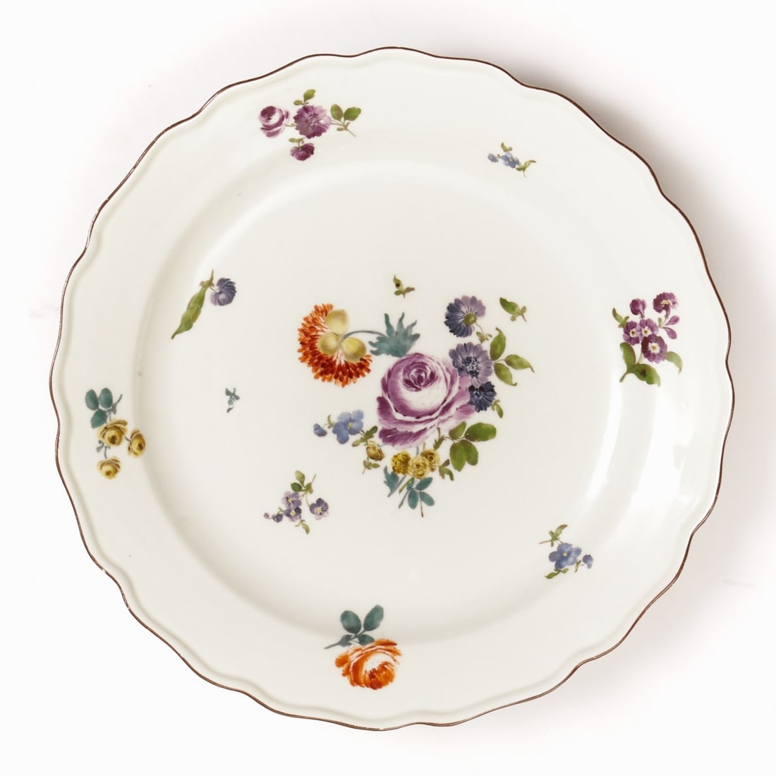 Plate - flower bouquet / Mannerist flowers: Plate - flower bouquet / Mannerist flowers Meissen, circa 1750. Porcelain, white, glazed. Polychrome painted. Brown rim. Underglaze blue sword mark. 1st choice. H. 4 cm, D. 26 cm. Mannerist flowers wi