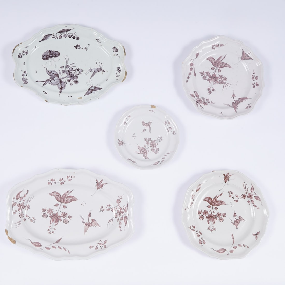 4 plates and 1 dish with bizarre flowers, crane and insects. Lunéville, mid-18th century.: 4 plates and 1 dish with bizarre flowers, crane and insects Lunéville, mid-18th century. Faience, beige body. Differently white glaze. Painted in manganese colors. - Provenance: One plate forme