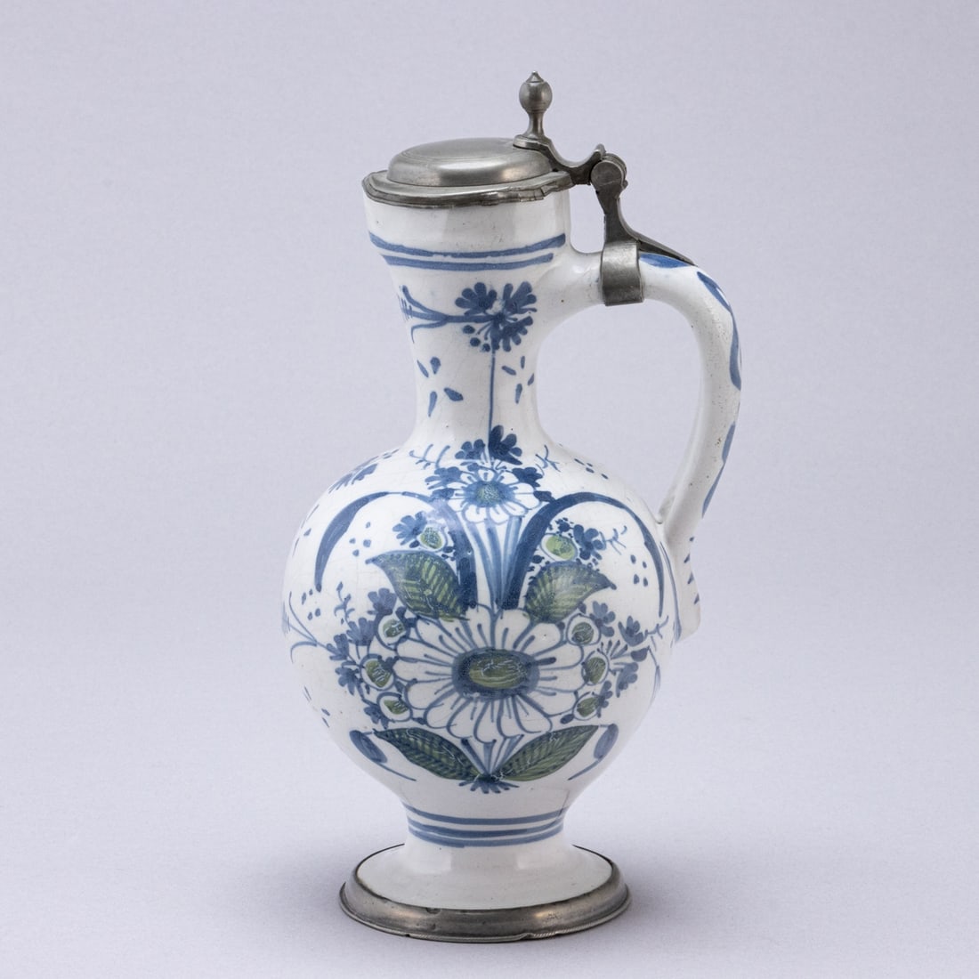 Narrow-necked jug with sunflower bouquet. Hanau, 2nd quarter 18th century.: Narrow-necked jug with sunflower bouquet Hanau, 2nd quarter 18th century. Faience, beige body. Milky white glaze. Fine craquelure. Painted in blue and green. Wiped base with indistinct blue mark.