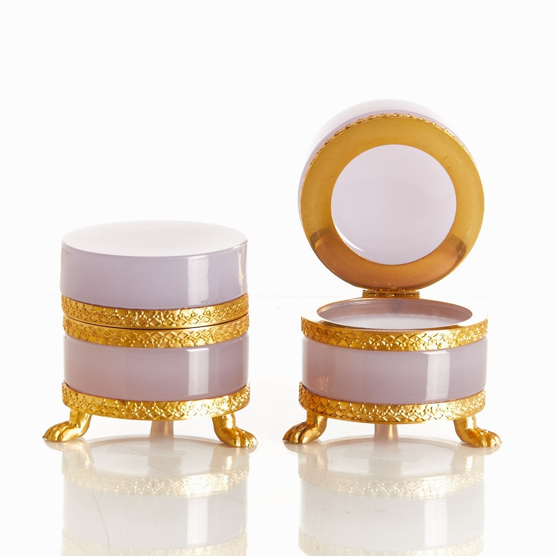 Pair of round lidded boxes on mounting with lion feet - Art Deco. France, circa 1935-1940.: Pair of round lidded boxes on mounting with lion feet - Art Deco France, circa 1935-1940. Thick-walled, alexandrite glass / rare earth oxides neodymium (violet / green) - opal glass, cut and polished.