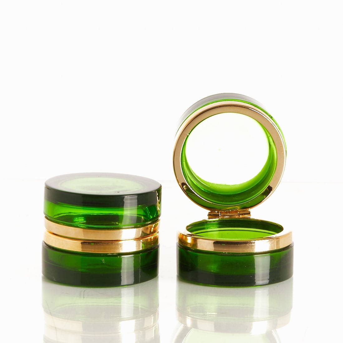 Pair of round covered boxes - Art Déco. France, circa 1935-1940.: Pair of round covered boxes - Art Déco France, circa 1935-1940. Thick-walled, dark green glass, cut and polished. Brass mounting with hinge. H. 4.5 cm, D. 6 cm.