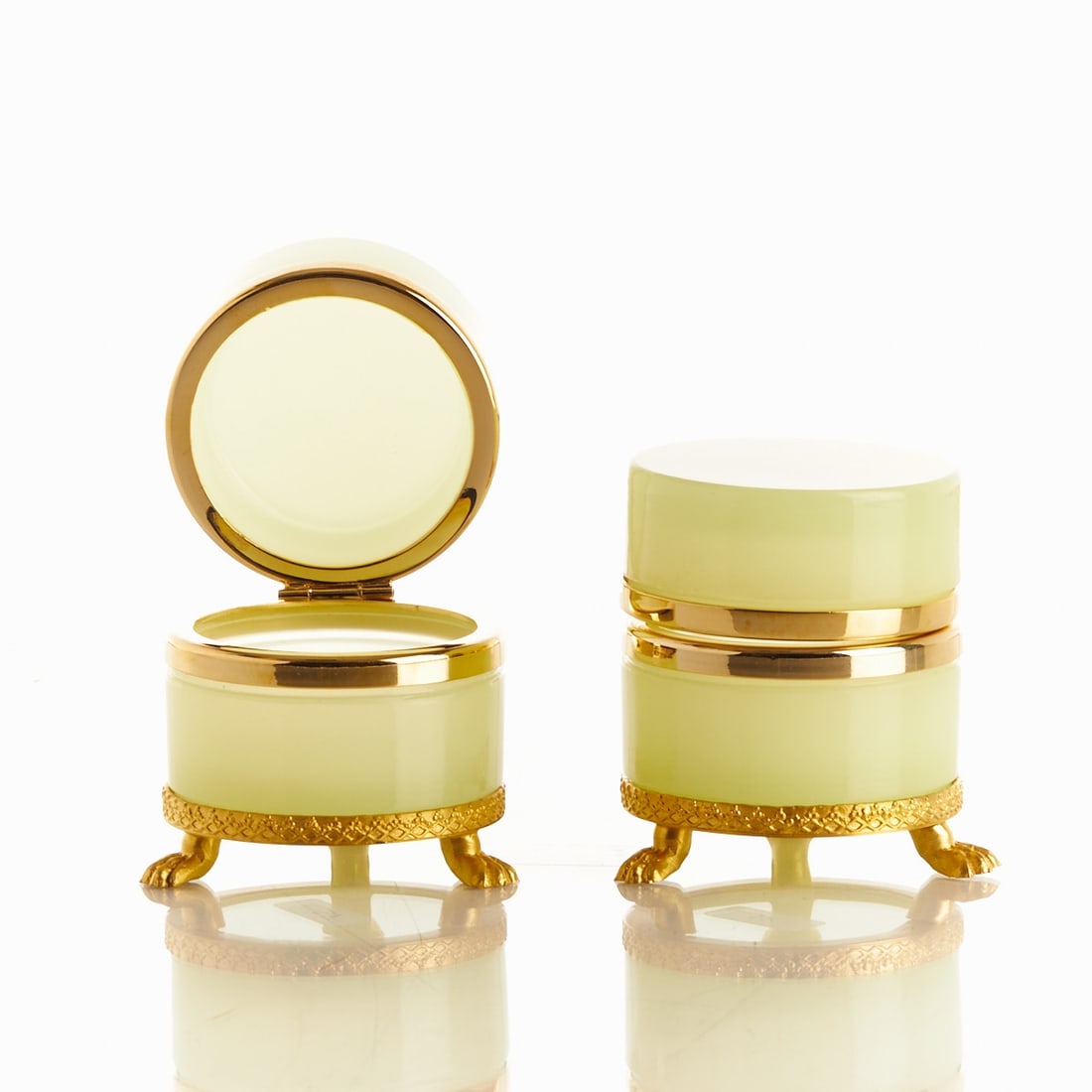 Pair of round lidded boxes on mounting with lion feet - Art Déco. France, circa 1935-1940.: Pair of round lidded boxes on mounting with lion feet - Art Déco France, circa 1935-1940. Uranium glass: Thick-walled, light green opal glass (apple green), slightly translucent, cut and polish