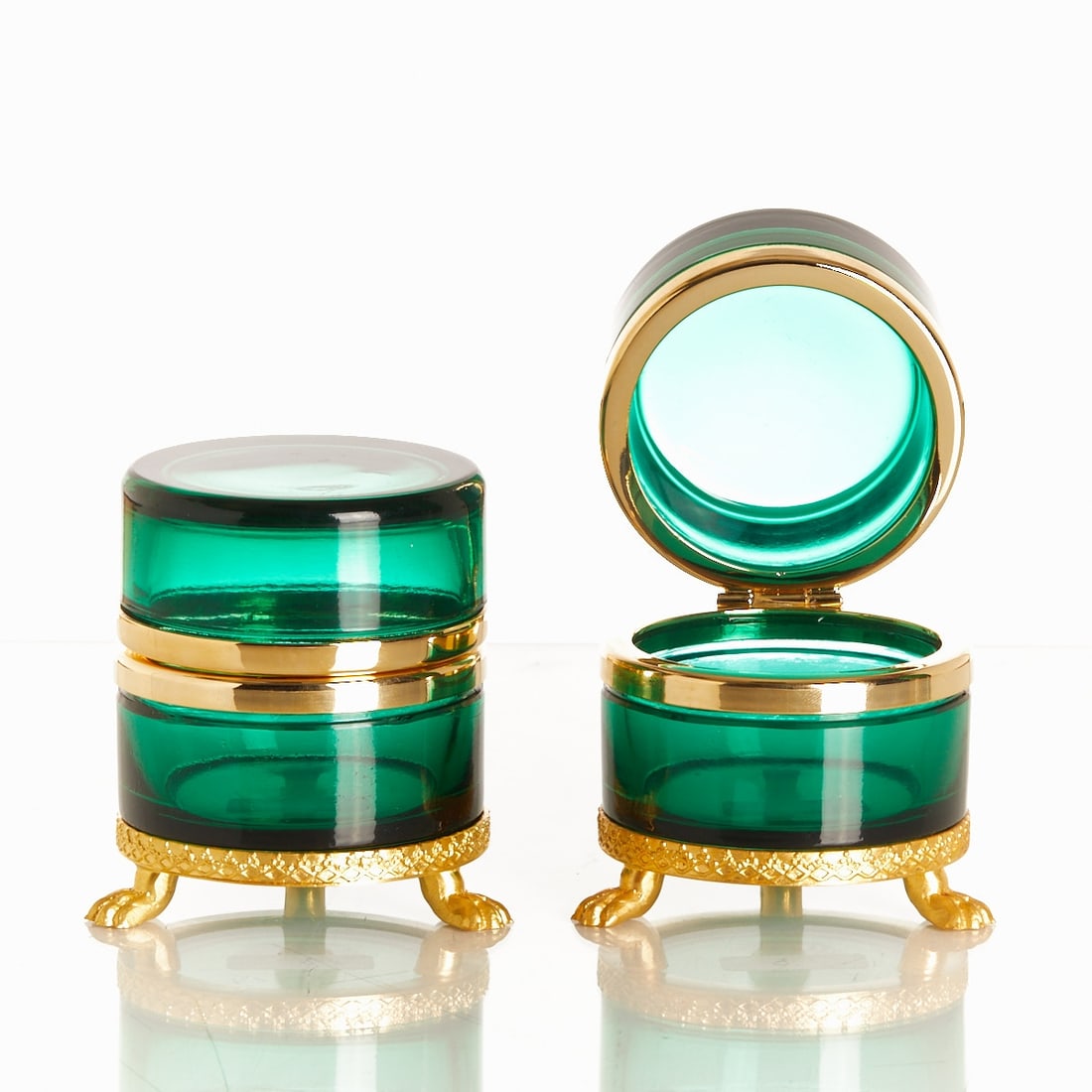 Pair of round lidded boxes on lion feet - Art Deco. France, circa 1935-1940.: Pair of round lidded boxes on mounting with lion feet - Art Deco France, circa 1935-1940. Thick-walled, green glass, cut and polished. Brass mounting with hinge. Embossed mounting with lion feet. H. 7