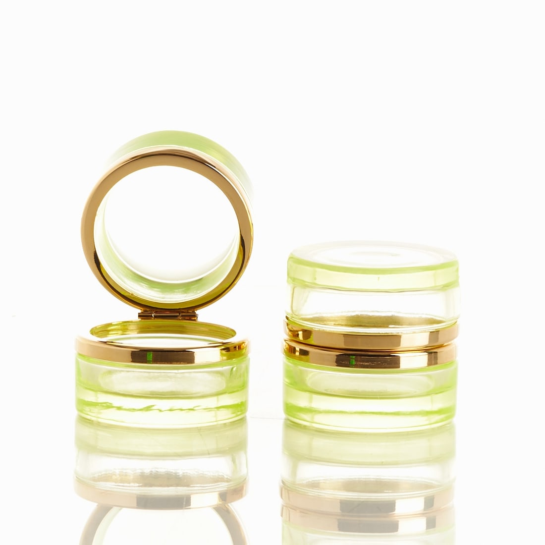 Pair of round lidded boxes - Art Déco. France, circa 1935-1940.: Pair of round lidded boxes - Art Deco France, circa 1935-1940. Uranium glass: Thick-walled, light green glass (apple green), cut and polished. Brass mounting with hinge. H. 6 cm, D. 6 cm.
