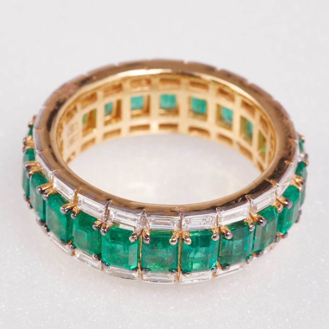Memory ring with emeralds: Memory ring with emeralds. 750/- yellow gold, stamped. Weight: 7.2 g. 22 emerald-cut emeralds totaling approx. 4.33 ct. 44 baguette-cut diamonds totaling approx. 1.32 ct (tw/vsi). Ring size 55. Very g