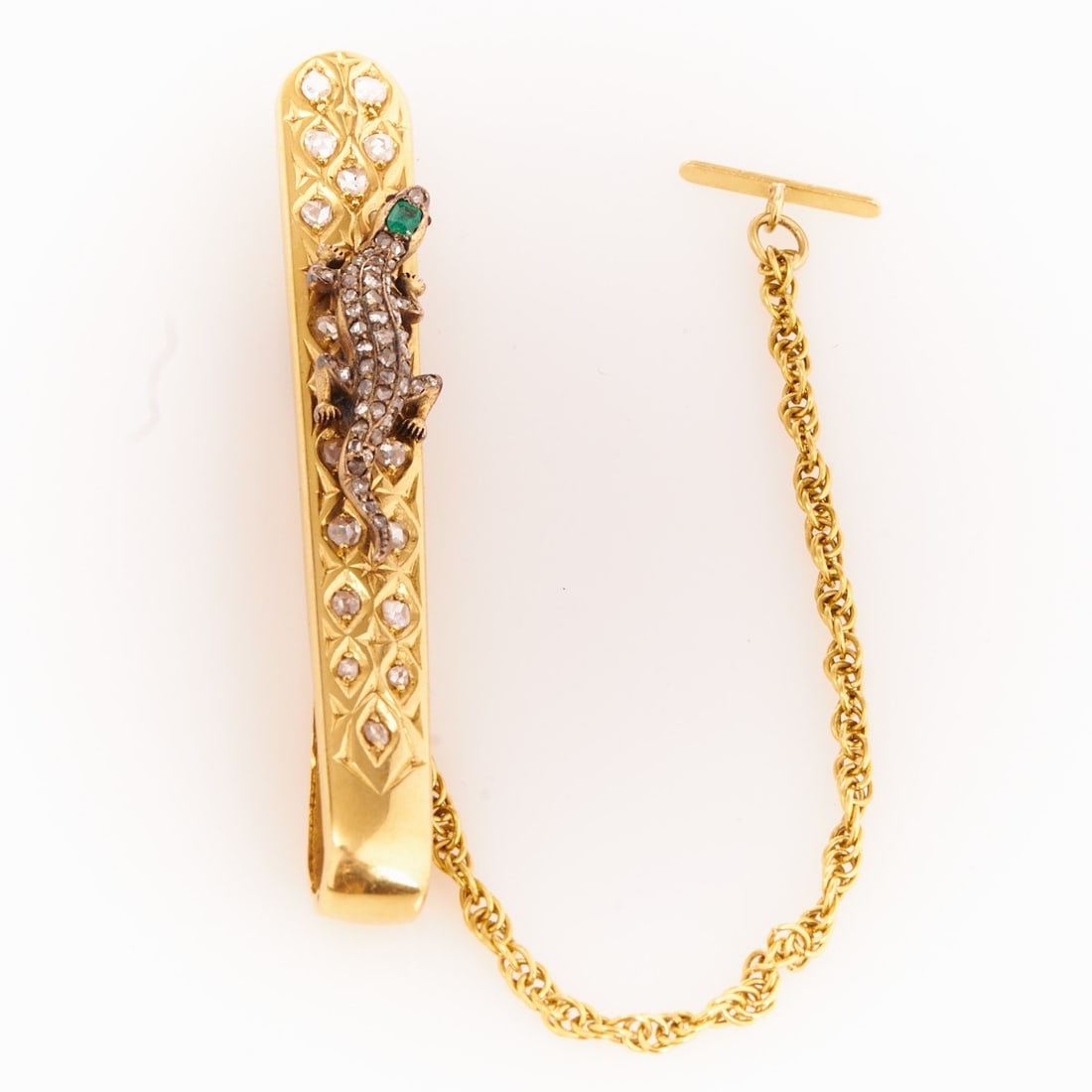 Tie Pin or Clip with a Lizard: Tie pin or clip with a lizard 585/- yellow gold and white gold, unstamped. Total weight: 14.3 g. 67 rose-cut diamonds of approx. 1.5 ct. 1 square faceted emerald and 2 small ruby cabochons. L. 7 cm.