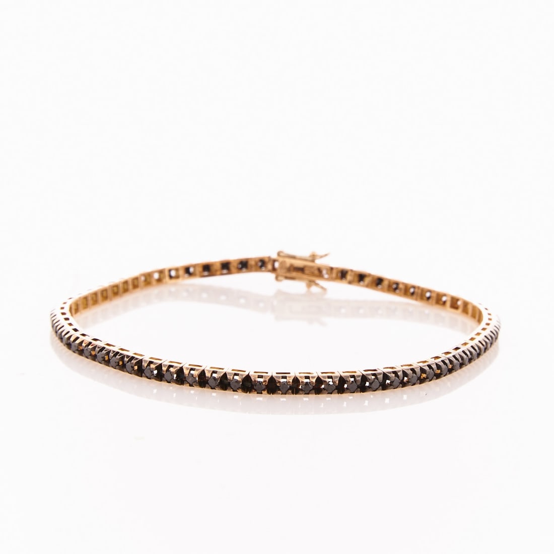 Tennis Bracelet with Black Diamond Setting: Tennis bracelet with black diamond setting 750/- yellow gold, hallmarked. Total weight: 9.21 g. 2 white brilliant-cut diamonds and approx. 61 black diamonds, all together 1.1 ct. L. 19.2 cm. W. 0.27 c