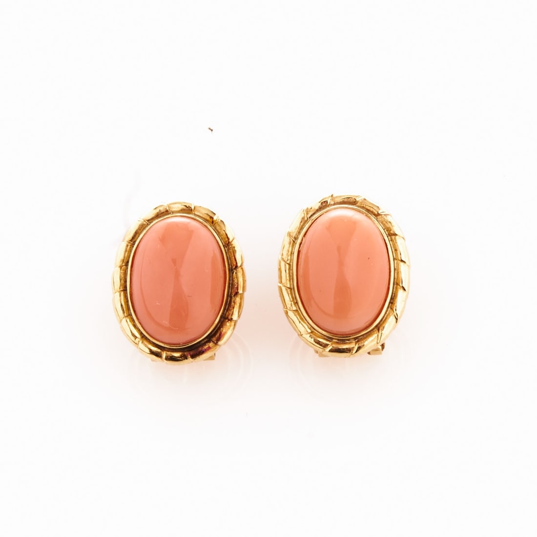 Pair of Coral Earrings: Pair of coral earrings. 585/- yellow gold, hallmarked. Total weight: 7.4 g. 2 angel skin coral. L. 1.8 cm. W. 1.5 cm. Studs with clip fasteners. Very good condition.