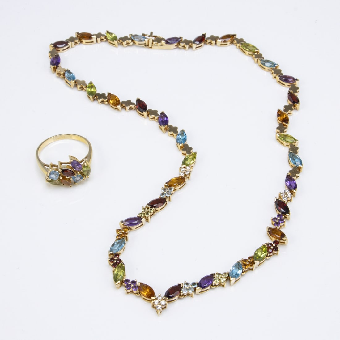 Multicolor jewelry set: Necklace and ring: Multicolor jewelry set: Necklace and ring 750/- yellow gold, hallmarked. Total weight: 36.2 g. Lavishly set with colorful gemstones, including citrines, amethysts, imperial topaz, garnets, peridots