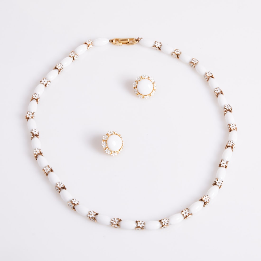 TRIFARI Alfred Philippe - White Pearl Necklace and a Pair of Clip-on Earrings: TRIFARI Alfred Philippe - White pearl necklace and a pair of clip-on earrings. Crown Trifari, New York, circa 1950. Gold-colored metal. Enamel. White glass pearls. Total weight: 54 g. Necklace