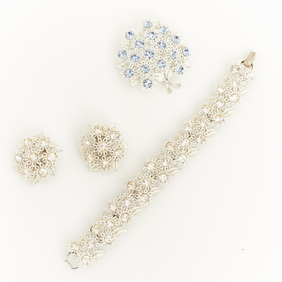 LISNER - Vintage Jewelry Set with Camille Blossoms (3 pieces): LISNER - Vintage Jewelry Set with Camille Blossoms (3 pieces) Bracelet, brooch, and pair of ear clips. Lisner, New York, approx. 1950. Metal, silver-colored; crystal rhinestones; enamel. Total weight: