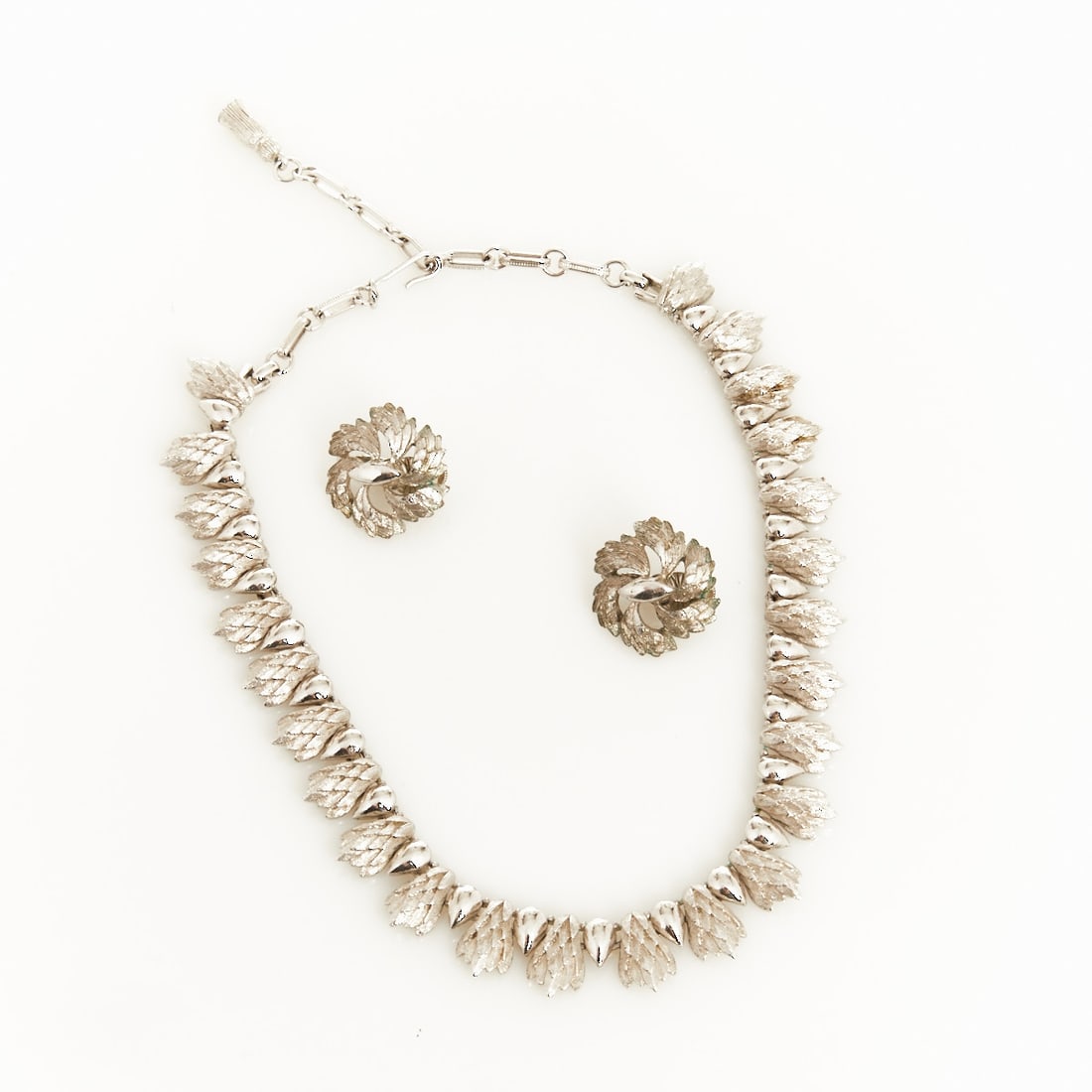 CORO - Silver-colored Vintage Necklace and Pair of Ear Clips with Leaf Motif: CORO - Silver-colored Vintage Necklace and Pair of Ear Clips with Leaf Motif Coro (Cohn & Rosenberger Jewelry), New York, USA, circa 1940s. Metal, silver-colored. Weight: 75 g. Necklace L. 37 - 45