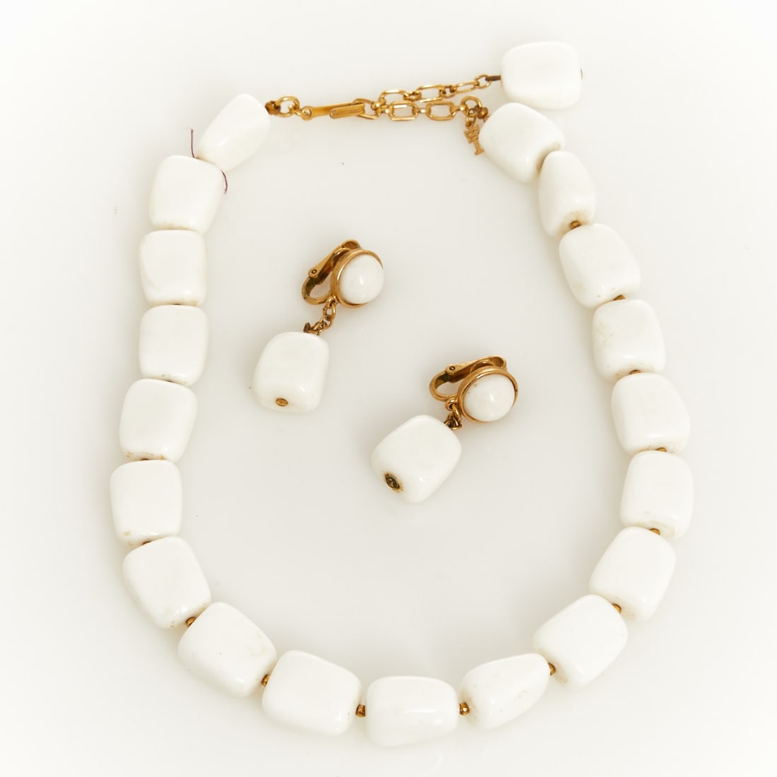 TRIFARI - Vintage Pearl Necklace and Pair of Ear Clips: TRIFARI - Vintage Pearl Necklace and Pair of Ear Clips Trifari, New York; approx. 1940 - 1970. Metal, gold-colored. Lucite, with small gold-colored beads between the white pearls. Weight: 50 g. Neckla