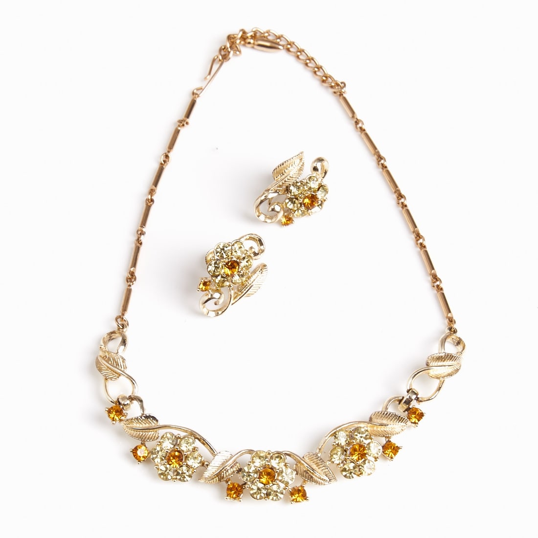 CORO - Vintage Necklace and Pair of Ear Clips with Flora Motif: CORO - Vintage Necklace and Pair of Ear Clips with Flora Motif Coro (Cohn & Rosenberger Jewelry), New York, USA, circa 1940s. Metal, gold-colored. Rhinestones. Weight: 36 g. Necklace-L. 40 cm, W.