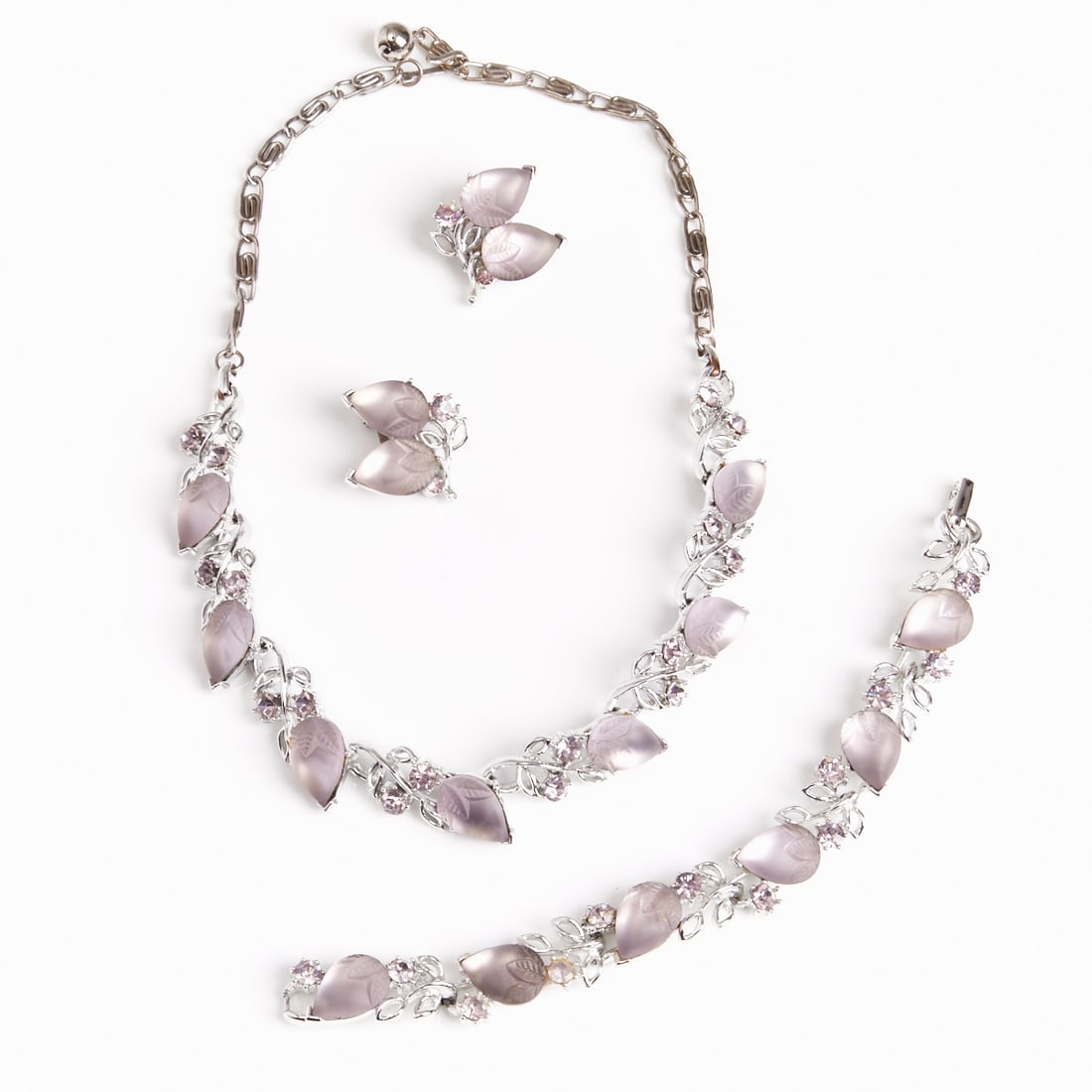 LISNER - Vintage Parure with Lilac Glass Cabochons (3 pieces): LISNER - Vintage Parure with Lilac Glass Cabochons (3 pieces) Necklace, bracelet and pair of ear clips. Lisner, New York, circa 1950. Metal, silver-colored; lilac pear-shaped glass cabochons; rhinesto