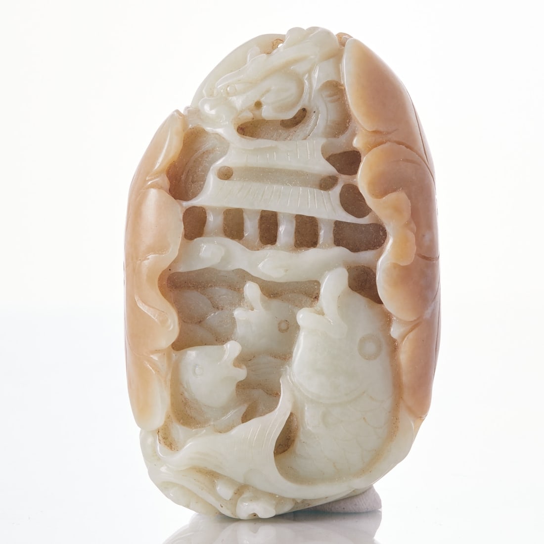 Large Carved Jade Pendant: Large Carved Jade Pendant China, 19th-20th century. Beautiful, heavy jade in celadon and brown tones. L. 9 cm. W. approx. 5.5 cm. H. approx. 2.3 cm. Motif: Dragon, fish, temple, and lotus leaf on the