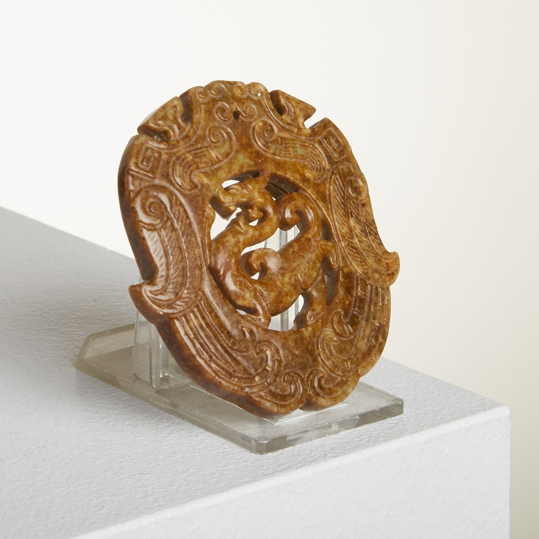 Jade Pendant with Qilin Depiction: Jade Pendant with Qilin Depiction China, probably 19th - 20th century. Jade, shades of dark and light brown marbling with green-colored inclusions. Dimensions: approx. 1 x 7 x 7.5 cm. Signs of age and