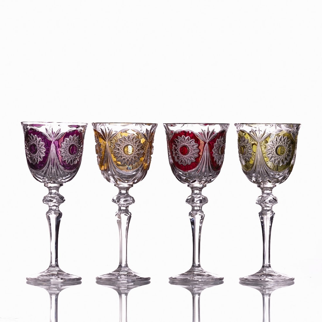 4 Roemer glasses with differently colored overlay.: 4 Roemer glasses with differently colored overlay Colorless glass, overlaid with amber, light green, violet, and red. Bowl with four cut stars. H. 22.5 cm.