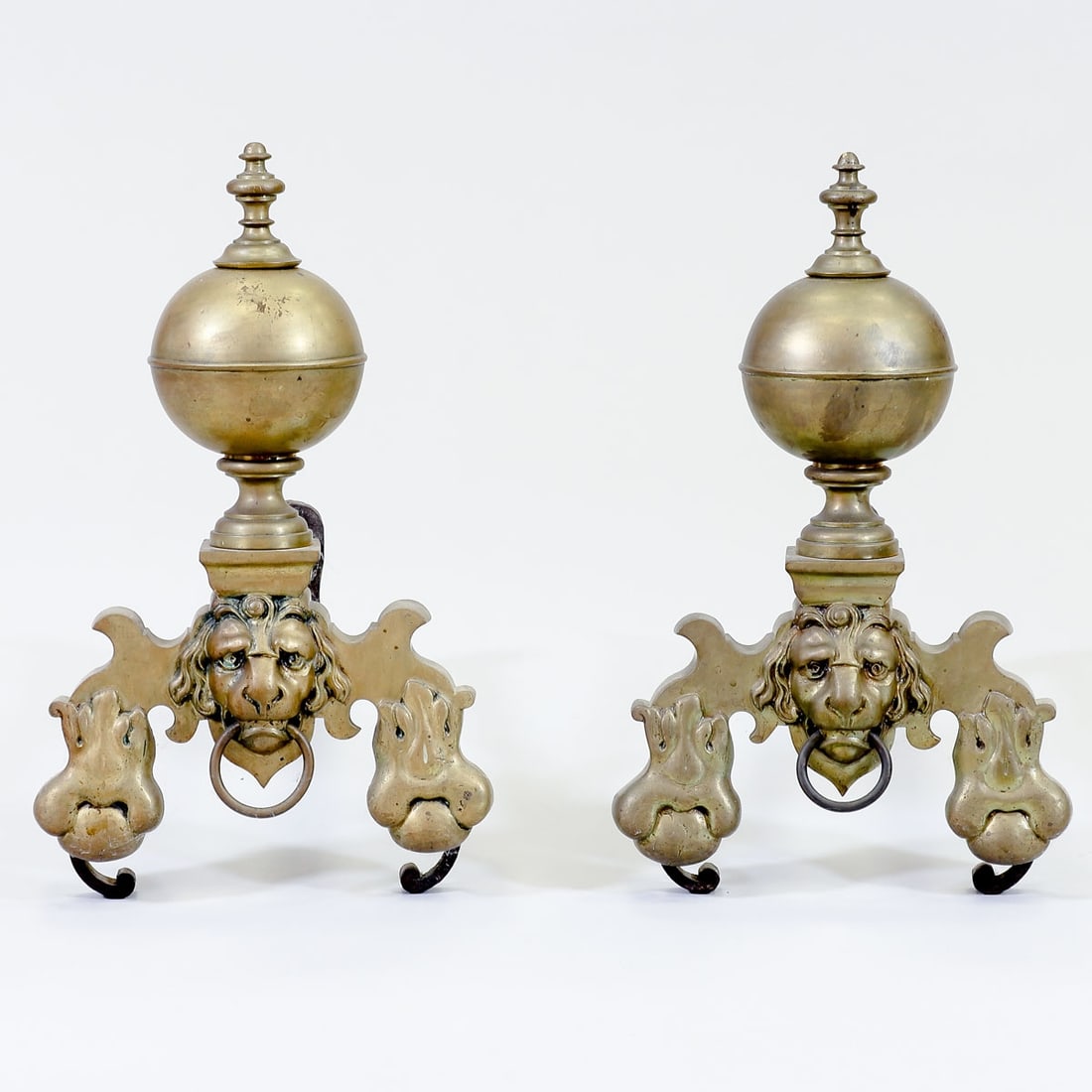 Pair of fire dogs with lion heads: Pair of fire dogs with lion heads France, 18th century. Bronze. Iron. 50 x 30 x 48 cm. On curved legs. Richly decorated with acanthus leaf decor and a lion's head with a ring. Concluding with a large