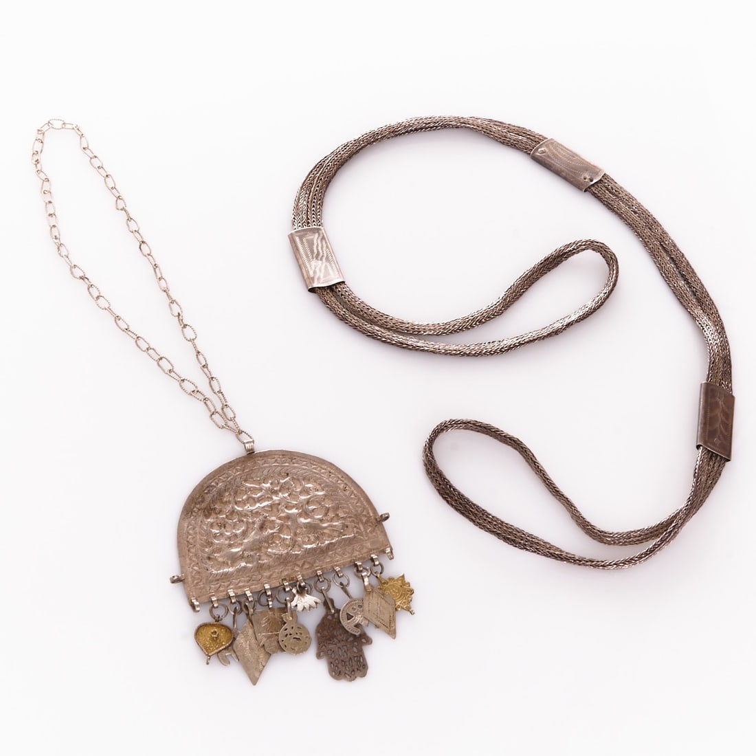 Pair of ethnological necklaces: Pair of ethnological necklaces Oriental / North African cultural sphere, 19th/20th century. Probably silver, hallmarked, crafted in elaborate braiding with rectangular decorative elements and traditio