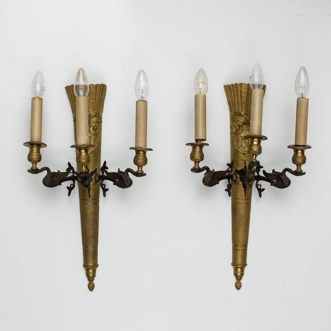Pair of 3-light wall lights in Empire style with swans: Pair of 3-light wall lights in Empire style with swans France, 19th century. Bronze. H. 51.5 cm. W. 32.5 cm. Medallion crowned with N and a French imperial eagle.