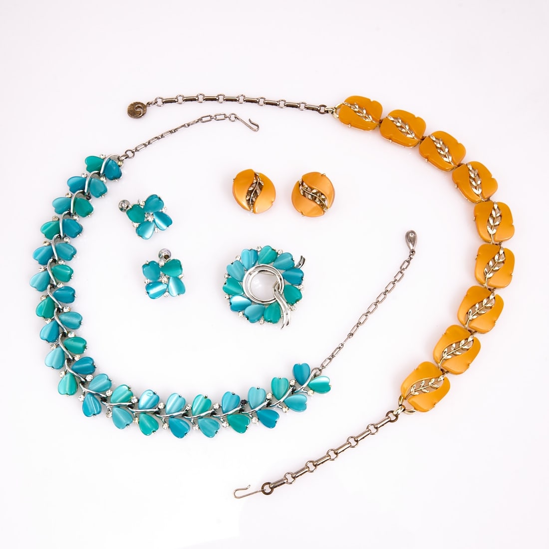 LISNER - Two vintage thermoset parures (5 pieces): LISNER - Two vintage thermoset parures (5 pieces) 2 necklaces, 1 brooch and 2 pairs of clip-on earrings. Lisner, New York, circa 1950. Metal, silver-colored, with green and orange thermoset; rhineston