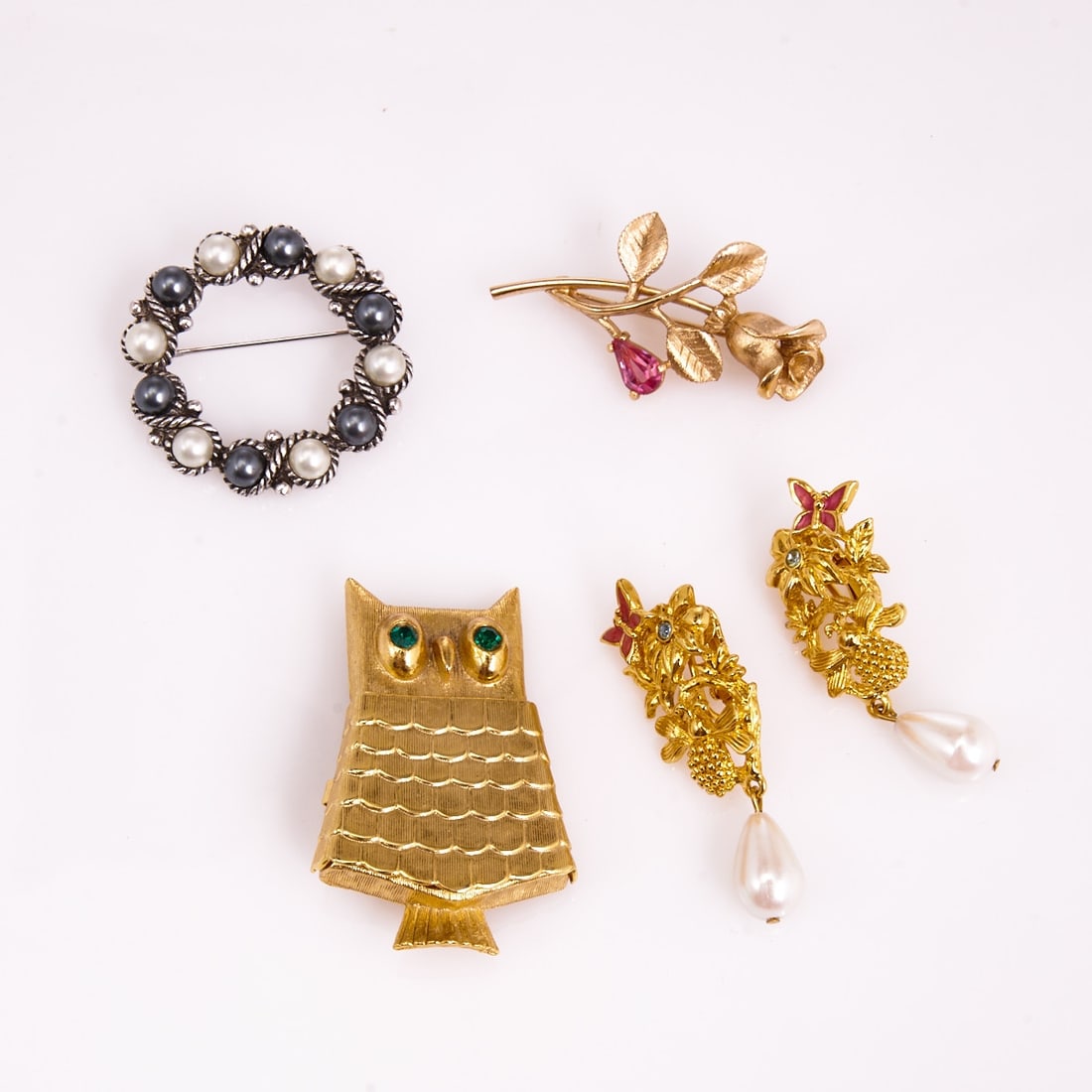 AVON - Three vintage brooches and a pair of clip-on earrings (4 pieces): AVON - Three vintage brooches and a pair of clip-on earrings (4 pieces) Avon company, circa 1960s - 1990s. Metal, gold-colored / silver-colored; faux pearls; rhinestones; faux emerald. Weight: 66 g. D